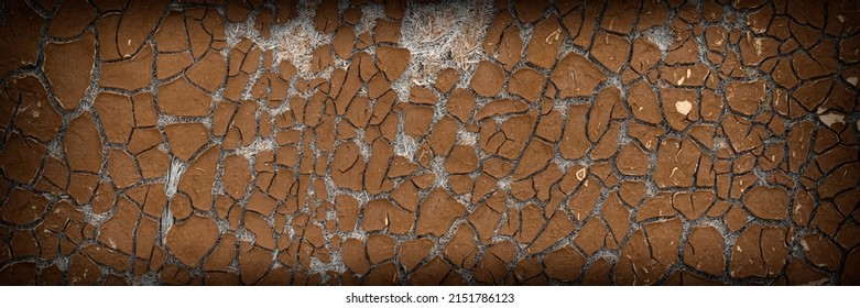Texture of old cracked artificial leather. The surface of the dried leatherette with lots of cracks and pieces of brown material. Faux leather texture. Wide panoramic background for design.