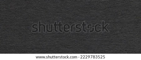 Texture of old dark gray paper closeup. Structure of a dense cardboard. The black background.