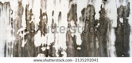 Texture of old gray concrete wall for background. Rust​ damaged​ to​ surface​ wall​ concrete​ for​ background​. Rough texture on gray wall rough form due to peeling paint layer due to rain.	
