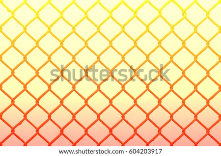 Texture of an old and rusty metal mesh on a neutral colored background. A sad and gloomy image with a flat fencing net used in prisons or industrial plants