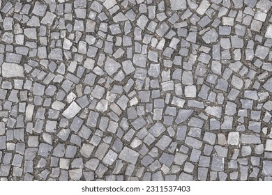 Texture of an old stoneblock pavement cobbled with gray stone tiles of different shapes as a background. Top view - Powered by Shutterstock