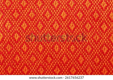 Texture of orange linen fabric with a pattern. Pattern on textiles
