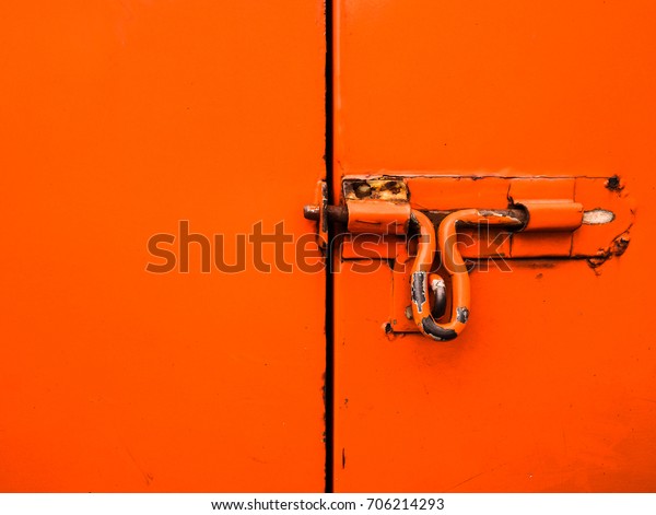 texture of orange metal door with lock, part of\
electric service truck, old and\
rusty