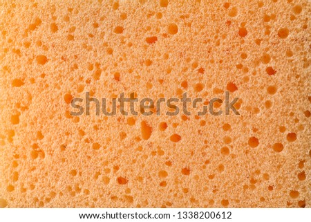 Texture of orange sponge as background, closeup