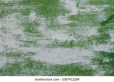 The texture of the peeled metal gate with green paint