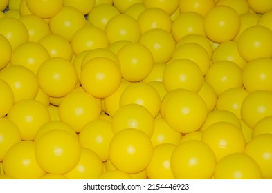 Texture Of Plastic Balls For Children. Background Of Yellow Balloons. Pile Of Toy Balls For Dry Pool