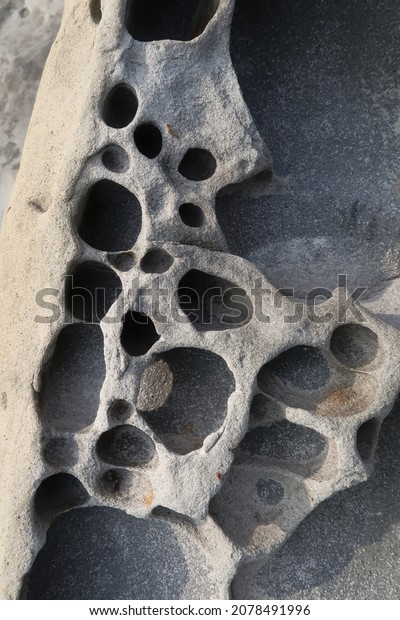 texture of porous stones on\
the beach