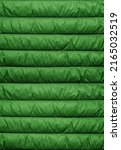 Texture of puffer, padded, down jacket. Background of urban winter outfit. Quilted pattern.
