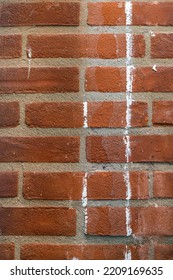 Texture Of A Red Brick Wall With Cement Masonry And White Paint Streaks
