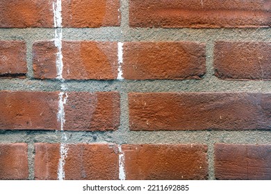 Texture Of A Red Brick Wall With Cement Masonry And White Paint Streaks
