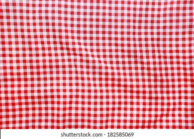 Texture of a red and white checkered picnic blanket. Red linen crumpled tablecloth.