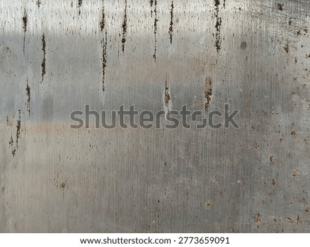 Texture of Scratched Metal Surface with Vertical Rust Stains. Industrial Grungy Stainless Steel Background with Corrosion, Scuffs, and Weathered Metallic Detail. Dirty Silver Steel Plate