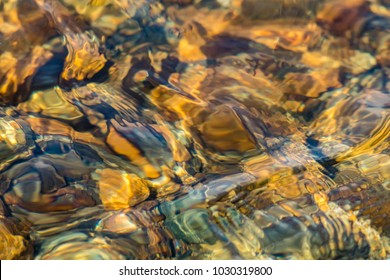 Texture Of Shallow Water Over Golden Brown River Rocks Creates A Unique Abstract Effect In Warm Tones