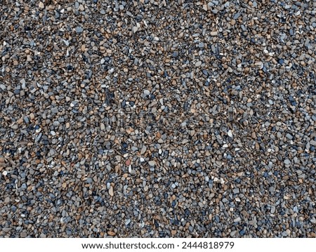 The texture of small variegated river stones. The background is made of small stones of different colors sifted from fine sand.