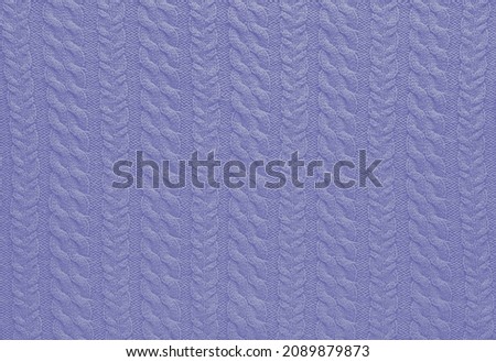 Texture of smooth knitted sweater with pattern. Handmade knitting wool or cotton fabric texture. Background of knitting patterns with a vertical Braid Cable. Color Of The Year 2022 - Very Peri.