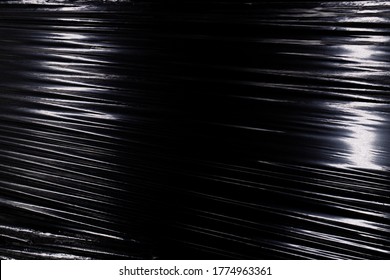 Texture Of A Stretched Plastic Film On A Black Background, Food Rumpled Cellophane Wrap