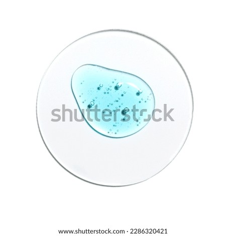 Texture swatch of blue hyaluronic acid serum gel on white isolated background, macro. Detergent, cosmetics, laboratory. A round drop in a petri dish