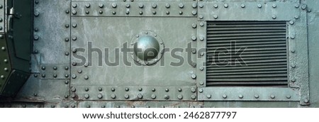 Texture of tank side wall, made of metal and reinforced with a multitude of bolts and rivets. Image of covering of a combat vehicle from the Second World War