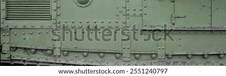 Texture of tank side wall, made of metal and reinforced with a multitude of bolts and rivets. Image of covering of a combat vehicle from the Second World War