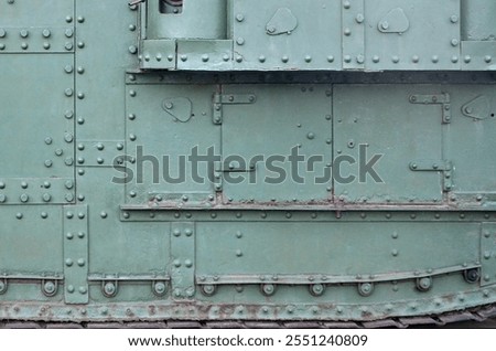 Texture of tank side wall, made of metal and reinforced with a multitude of bolts and rivets. Image of covering of a combat vehicle from the Second World War