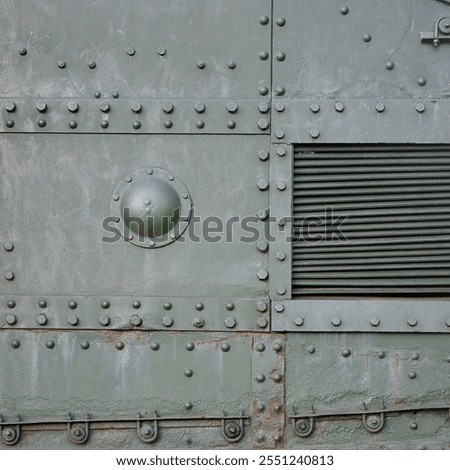 Texture of tank side wall, made of metal and reinforced with a multitude of bolts and rivets. Image of covering of a combat vehicle from the Second World War
