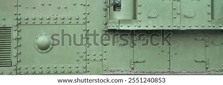 Texture of tank side wall, made of metal and reinforced with a multitude of bolts and rivets. Image of covering of a combat vehicle from the Second World War