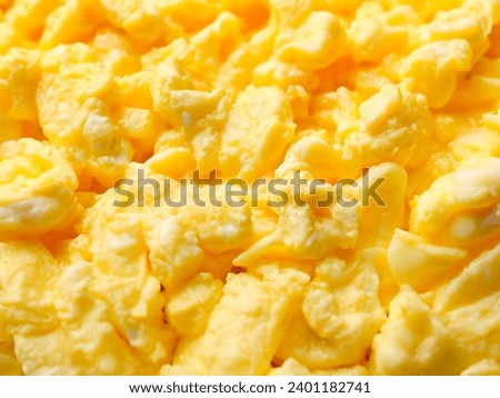 Texture of tasty scrambled eggs as background