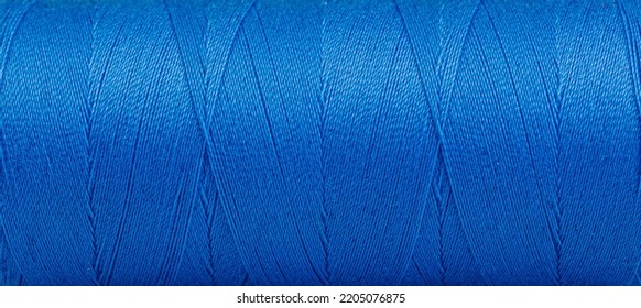 Texture of threads in a spool of blue color on a white background close-up - Shutterstock ID 2205076875