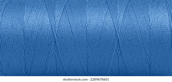 Texture of threads in a spool of blue color on a white background close-up