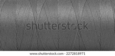 Texture of threads in a spool of grey color on a white background close-up