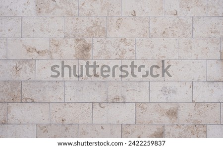 texture of a tiled beige stone wall as background