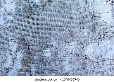 The Texture Of Torn White Fabric With A Large Cage Or Burlap, Curtain, Background
