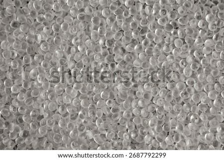 Texture of virgin polystyrene granules, close-up. Granulated plastic polymer. PS granules, transparent beads. Virgin GPPS pellets.