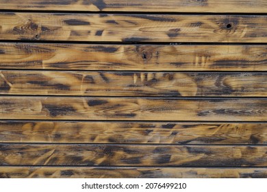 Texture of wall made of burnt and brushed wooden planks