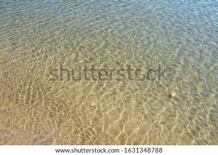 texture of water and sand, ripples of blue clear sea and sandy bottom visible, wallpapers about vacation and vacation