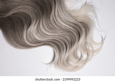 The Texture Of The Wavy Platinum Blond Hair With Highlights Isolated On The Grey Background