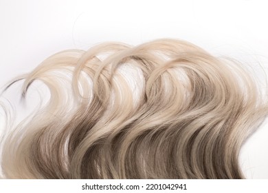 The Texture Of The Wavy Platinum Blond Hair With Highlights Isolated On The Grey Background