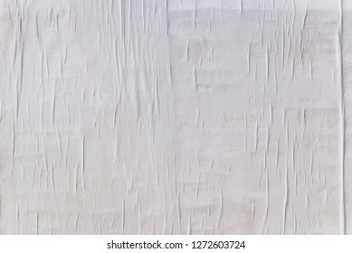 Texture Of Wet White Folded Paper On An Outdoor Poster Wall, Crumpled Paper Background.