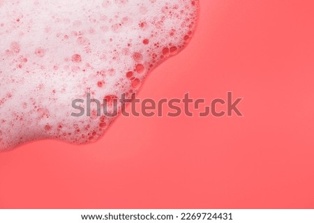 Texture of white foam with bubbles on pink background. Cosmetic foam for washing, hygiene, shampoo, soap, bathing gel, mousse. minimalistic cosmetic and medical background flat lay