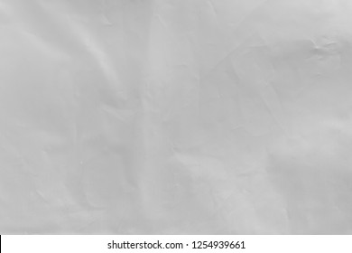 The texture of the white slightly crumpled ethylene-vinyl acetate (EVA) material. Background of synthetic fabric. 