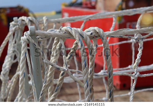 Texture of white and strong gangway net made of\
nylon fiber, as a grip and safety when crossing the ship\'s gangway.\
Safety net installed between the pier and the ship as a background\
or backdrop