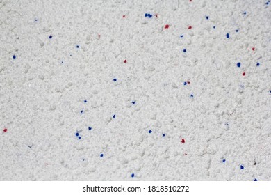 The texture of white washing powder interspersed with granules