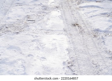 Texture Of White Winter Country Road, Tire Tracks And Shoe Prints In Snow