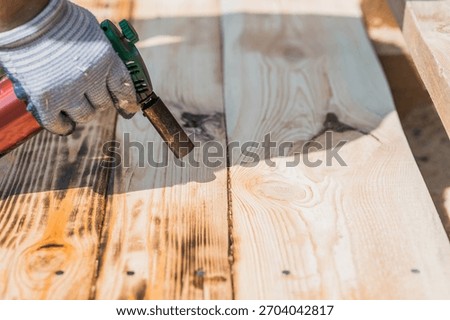 The texture of wood treated with fire using a burner. The process of burning wooden boards. Close-up.