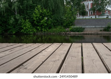 Texture of wooden desk on background of river, forest, ancient facade. - Powered by Shutterstock