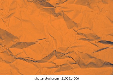 Texture of yellow crumpled paper. Orange background.