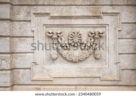 Textured background of aged stone wall of Dolmabahce Palace with carved floral pattern ornaments and carved details, Besiktas district, Istanbul, Turkey