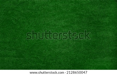 textured background surface of green textile upholstery wallpaper in close-up view. green color fabric structure detail. macro of a woolen cloth texture.