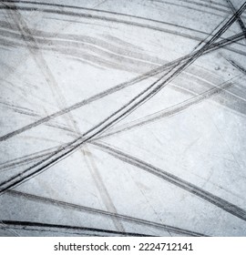 Textured background of vehicle traces on road from scooter, bike, bicycle weel. Tire print texture of transport - Shutterstock ID 2224712141