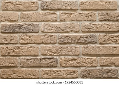 Textured beige brick wall, stone texture. decorative tiles for wall decoration. Background, beige decorative brick. loft decor style. structural surface, imitates old brick